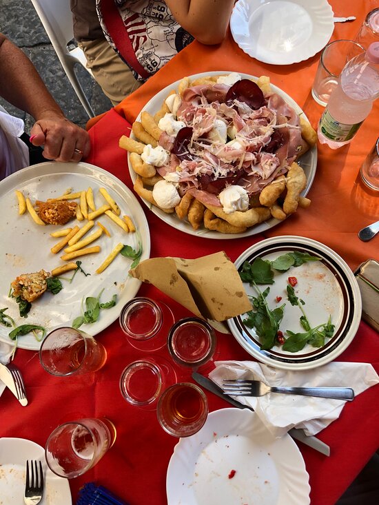 Tavolata con fritti, pizza e bevande